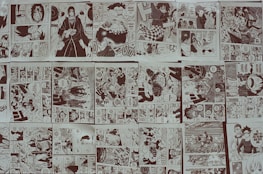 A close-up of colorful manga pages and comic strips overlapping on a dark surface.