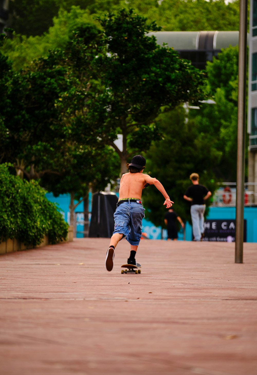 a young boy riding a skateboard down a sidewalk