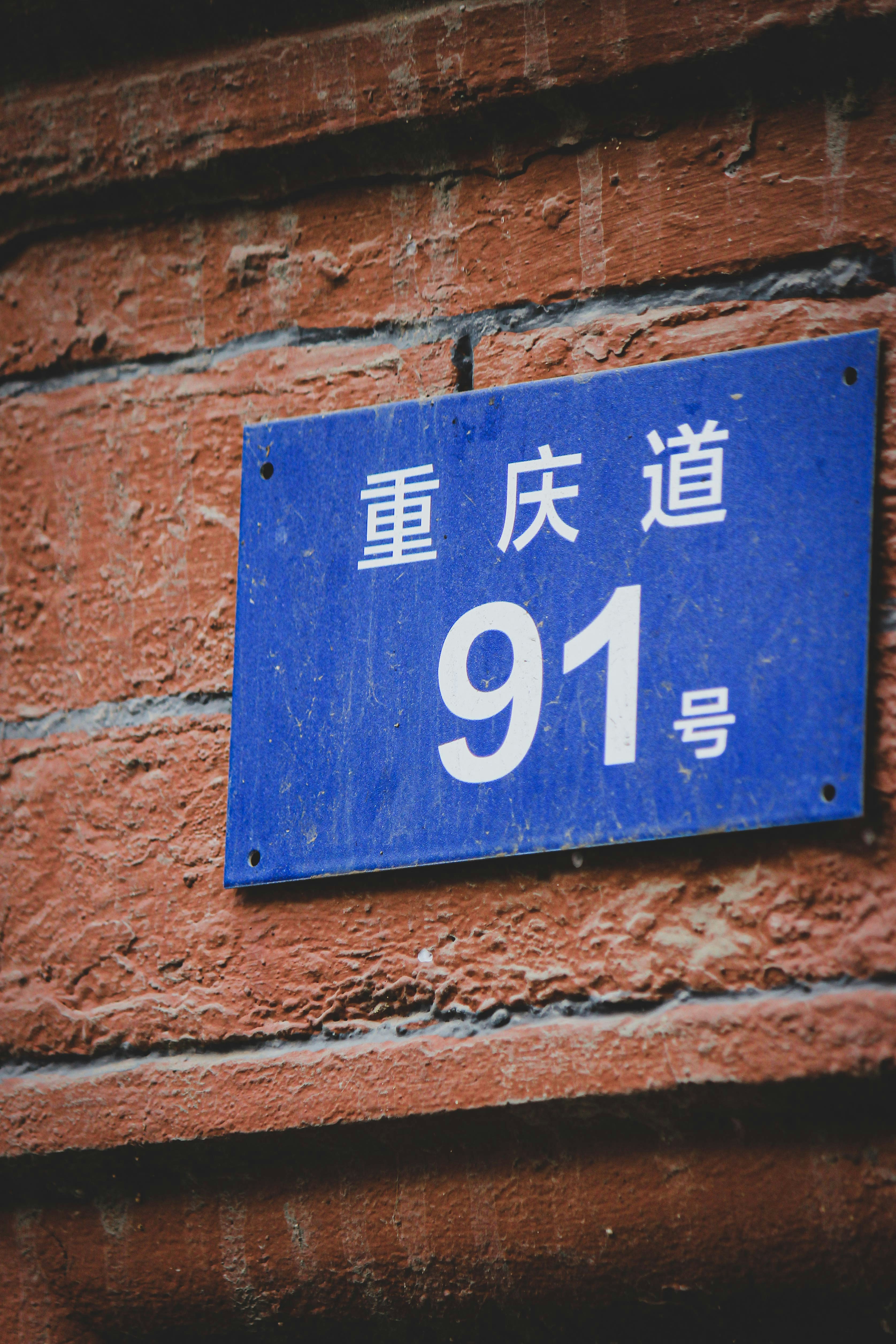 a blue street sign on a brick wall