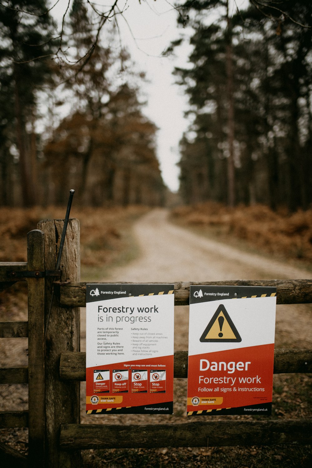 ein Schild an einem Zaun, das vor Waldarbeiten warnt