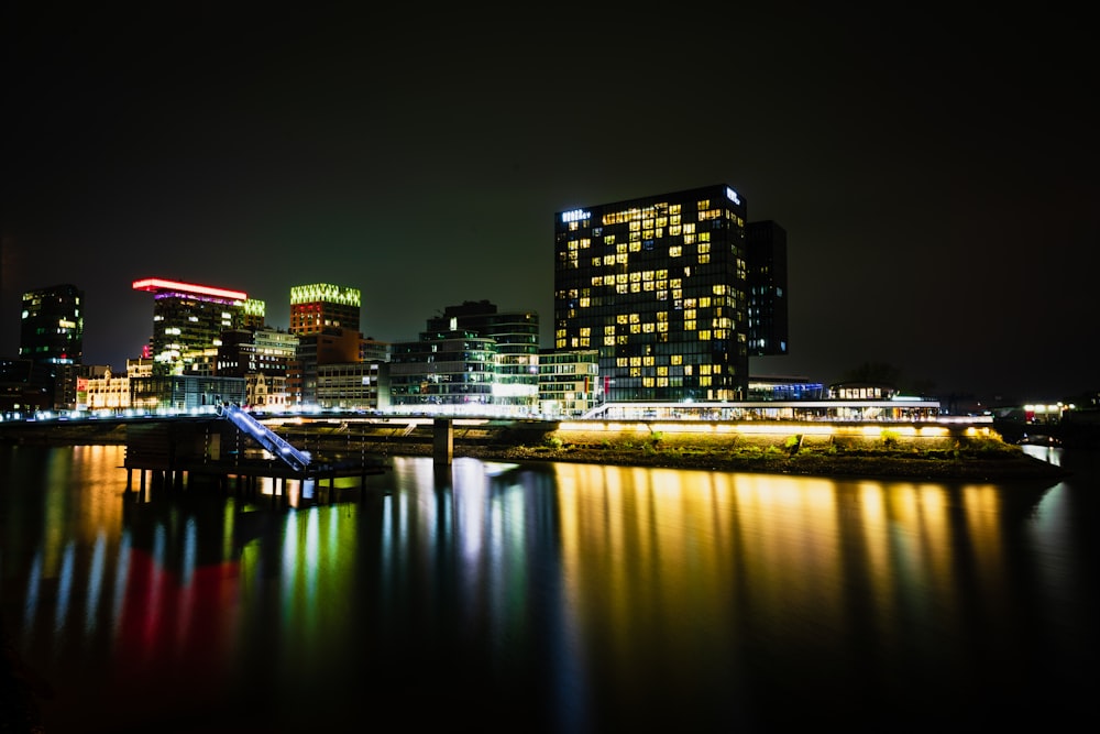 a city at night with lights reflecting in the water