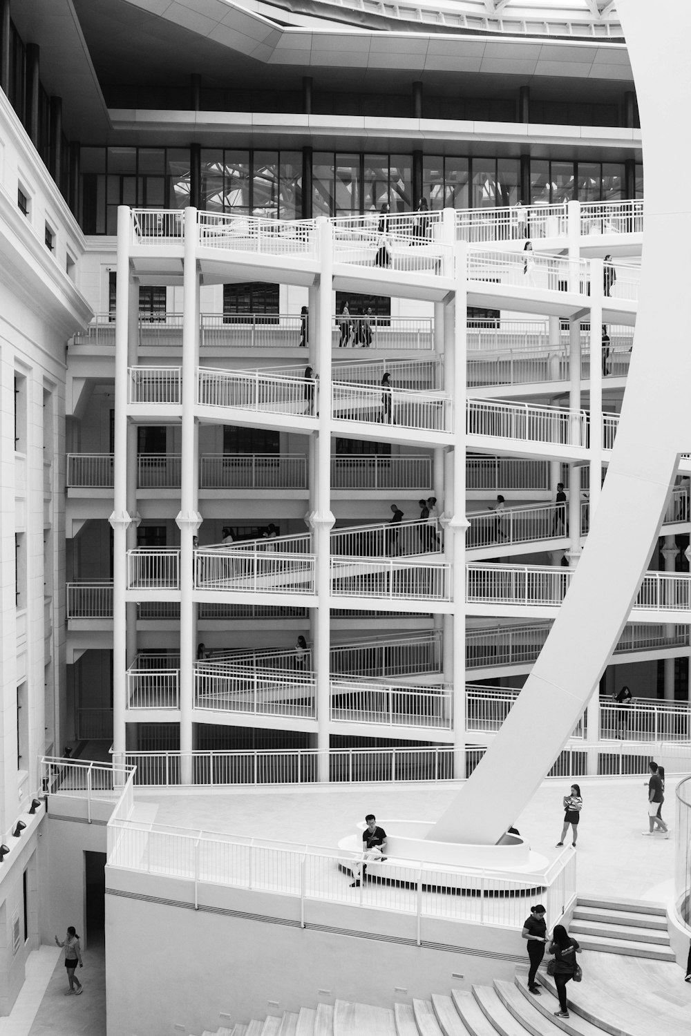 a black and white photo of people walking around a building