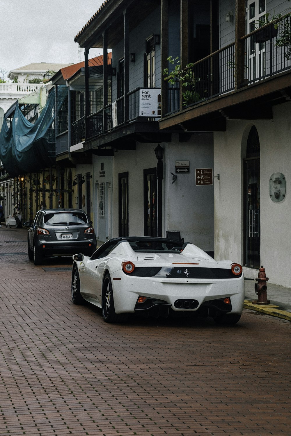 a white sports car parked in front of a building