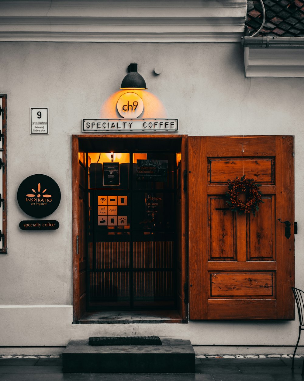 the front of a coffee shop with a wooden door