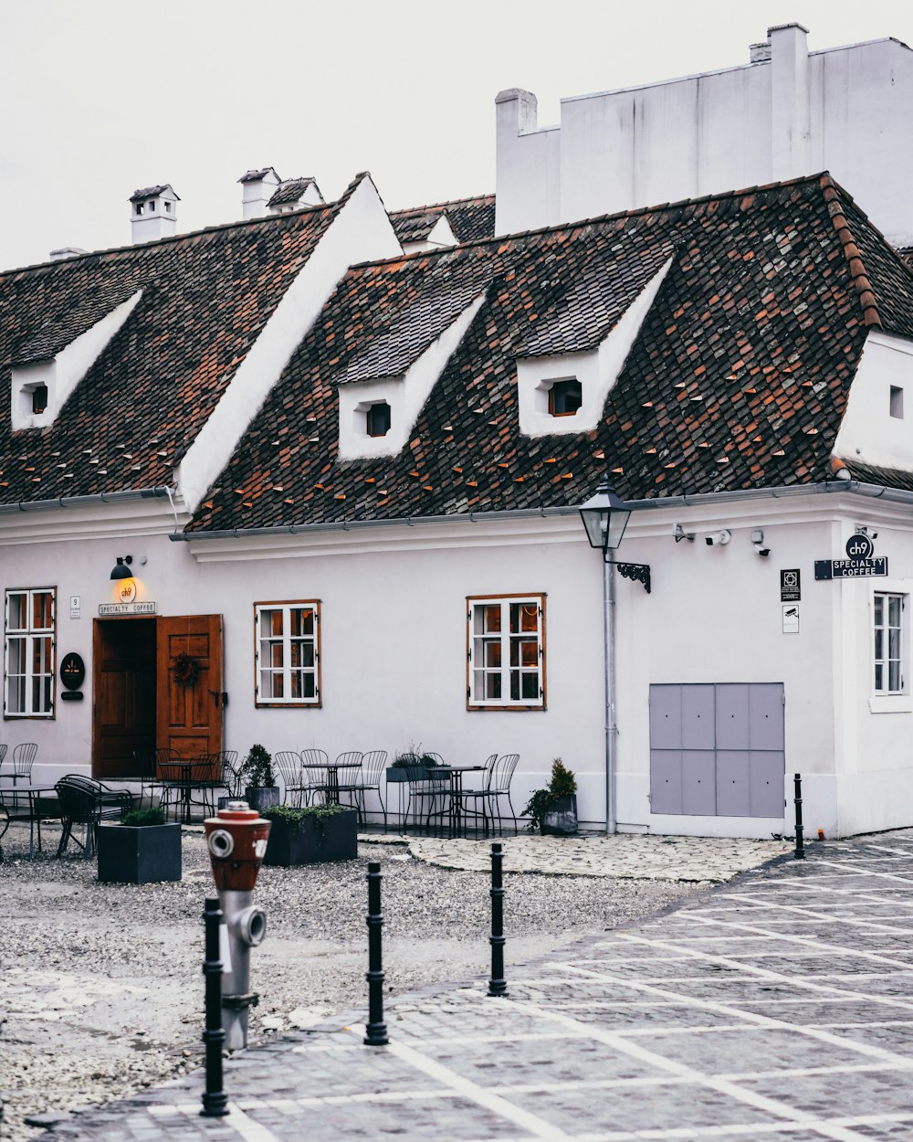 a white building with a red door and a red fire hydrant