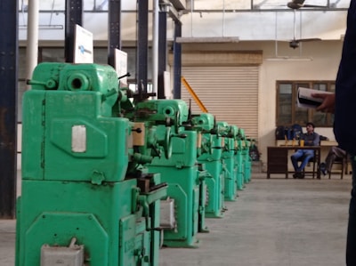 a row of green machines sitting inside of a building