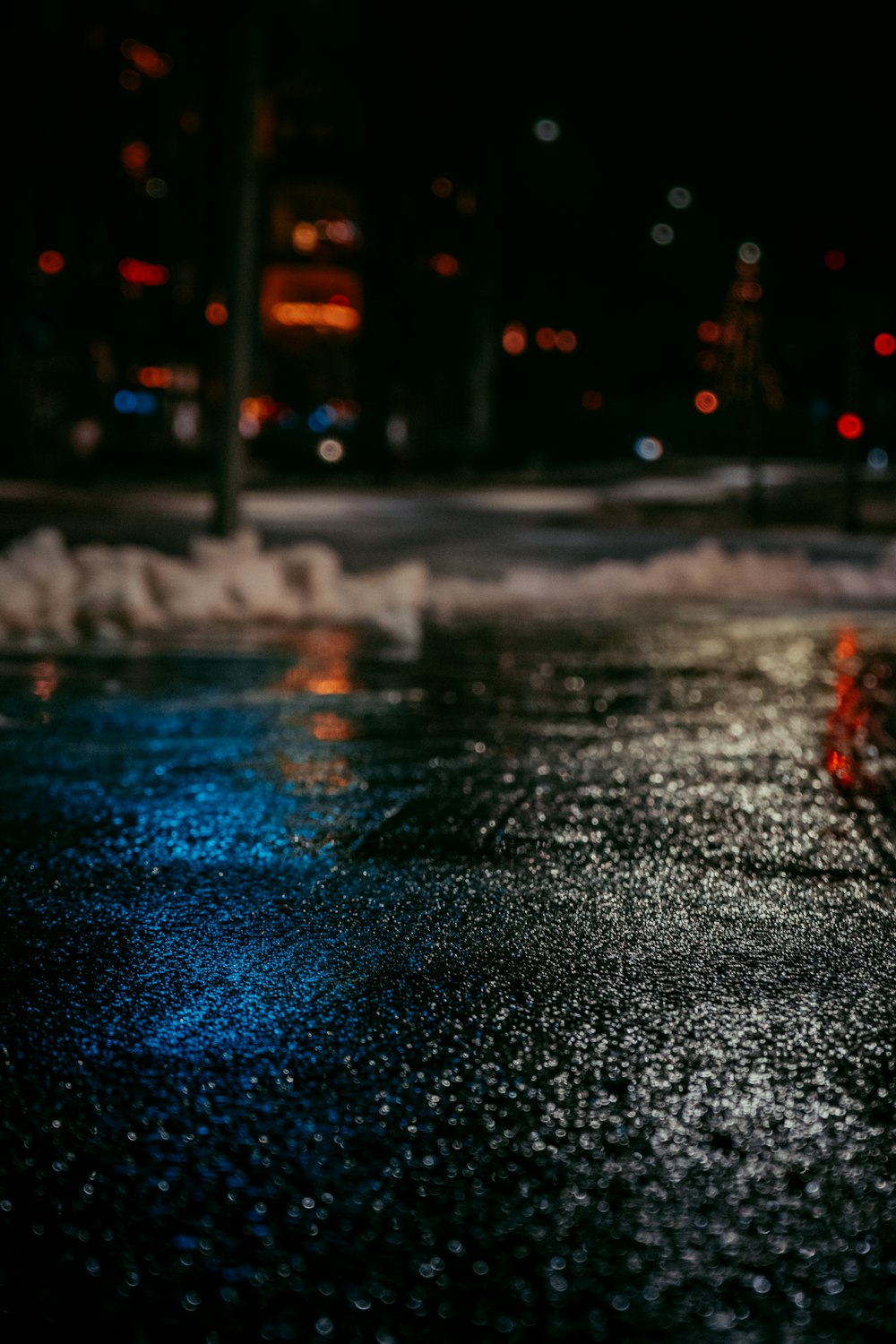 a wet street with a red fire hydrant in the middle of it