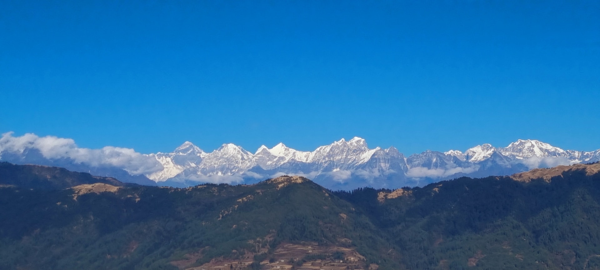a mountain range with snow capped mountains in the background