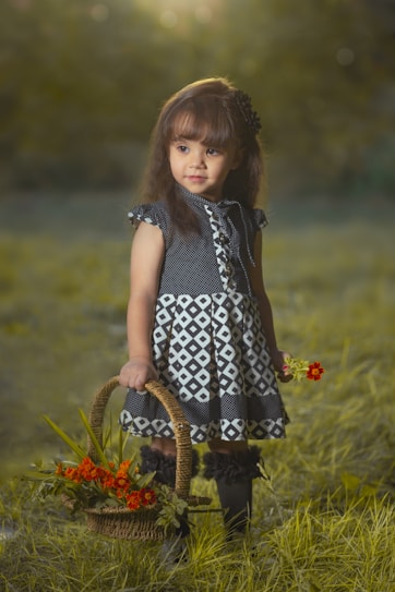 a little girl holding a basket of flowers