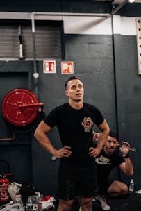 a man standing in a gym with his hands on his hips
