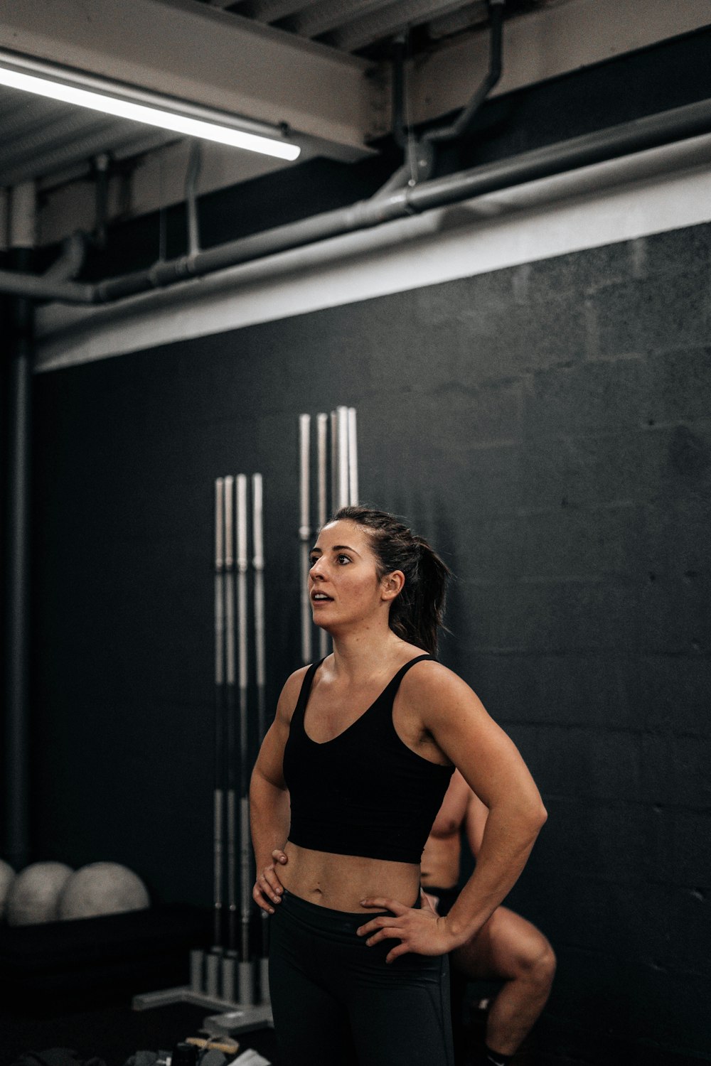 a woman standing in a gym with her hands on her hips