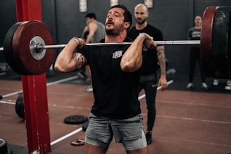 a man lifting a barbell in a gym