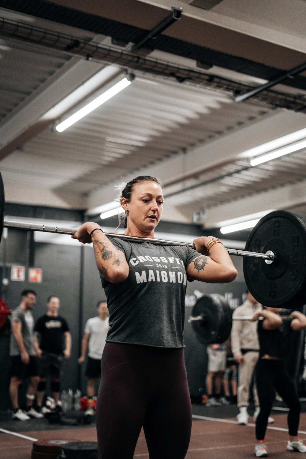 a woman lifting a barbell in a gym