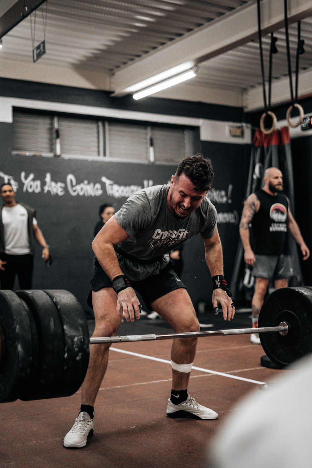 a man lifting a barbell in a gym