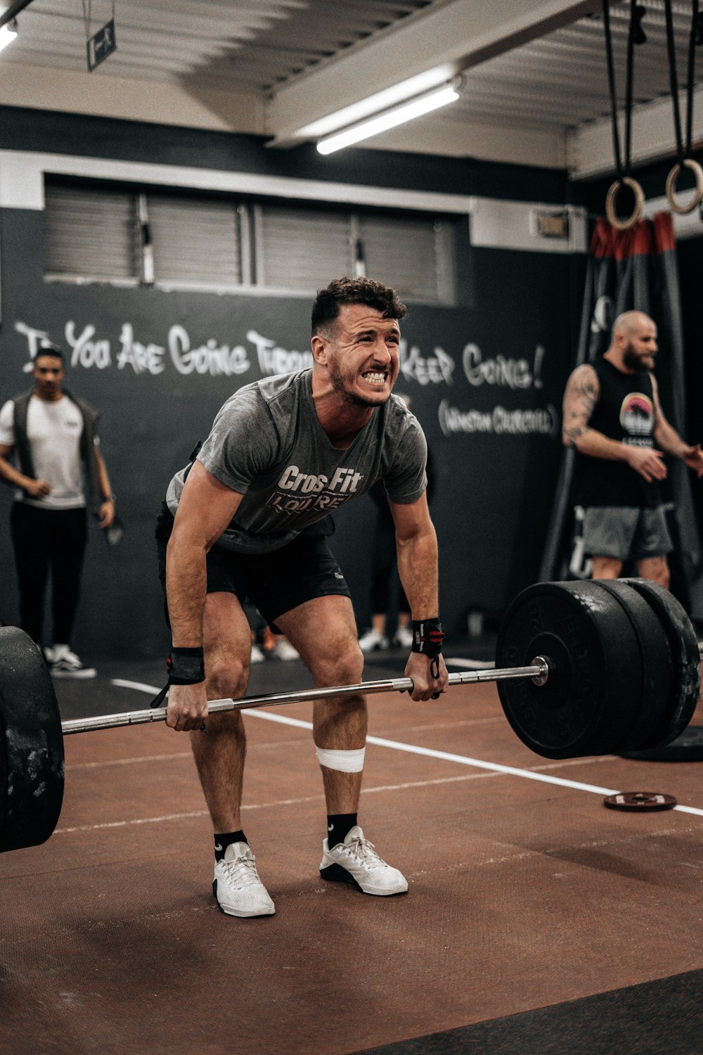 a man lifting a barbell in a gym