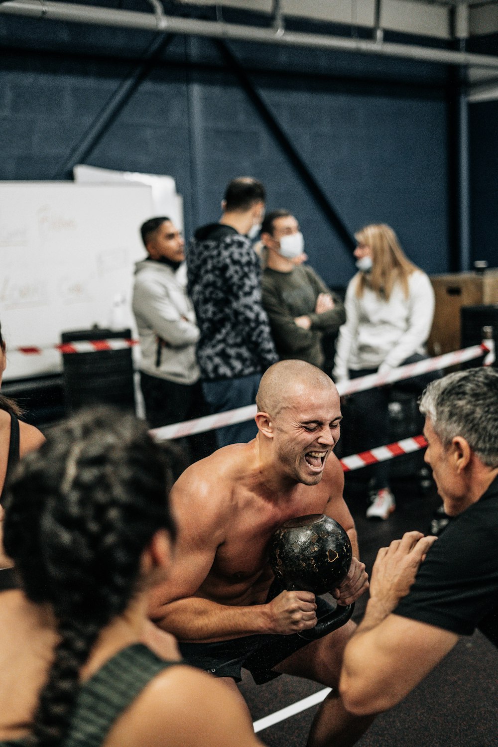 a group of people in a gym with one man holding a kettle