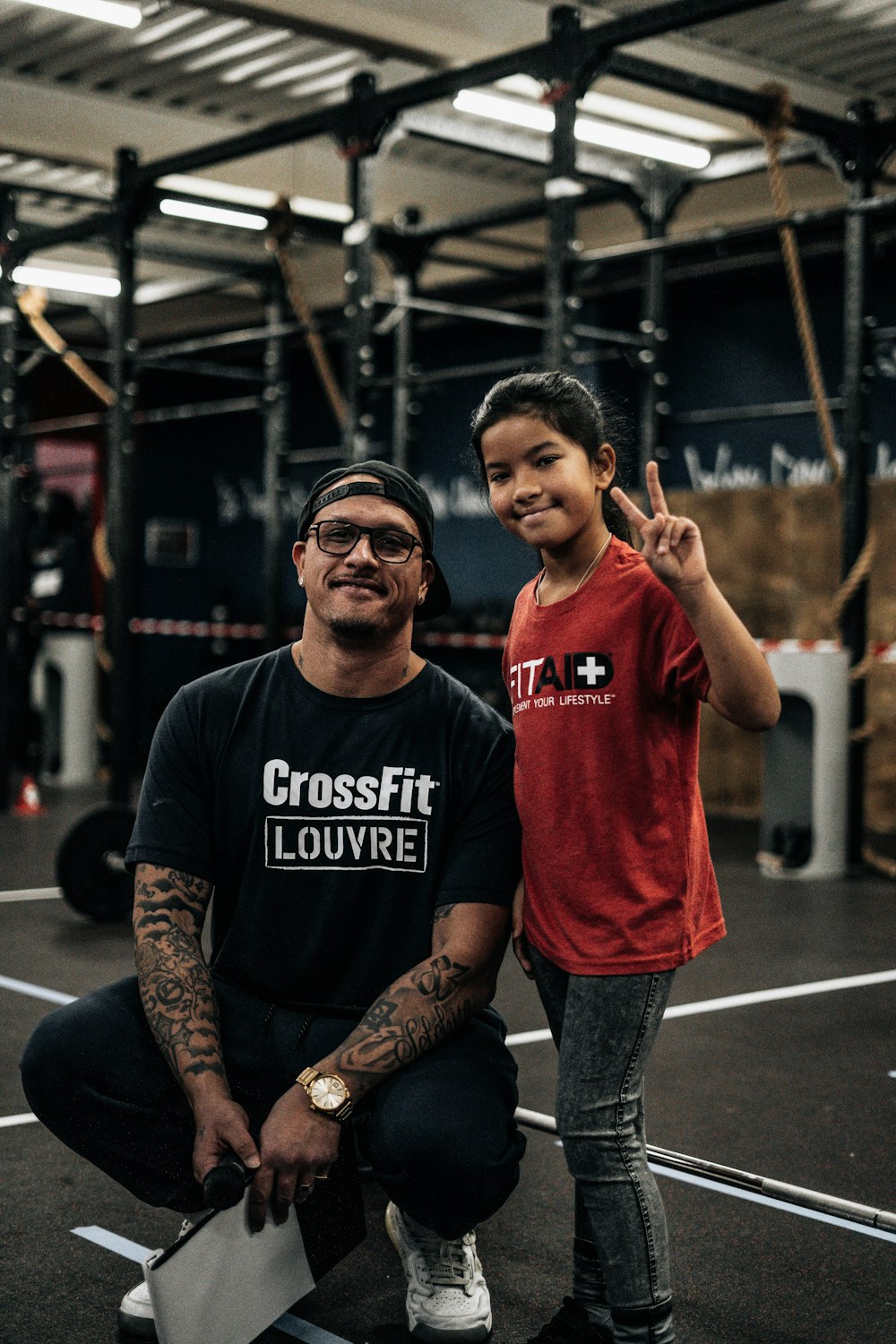 a man kneeling down next to a little girl