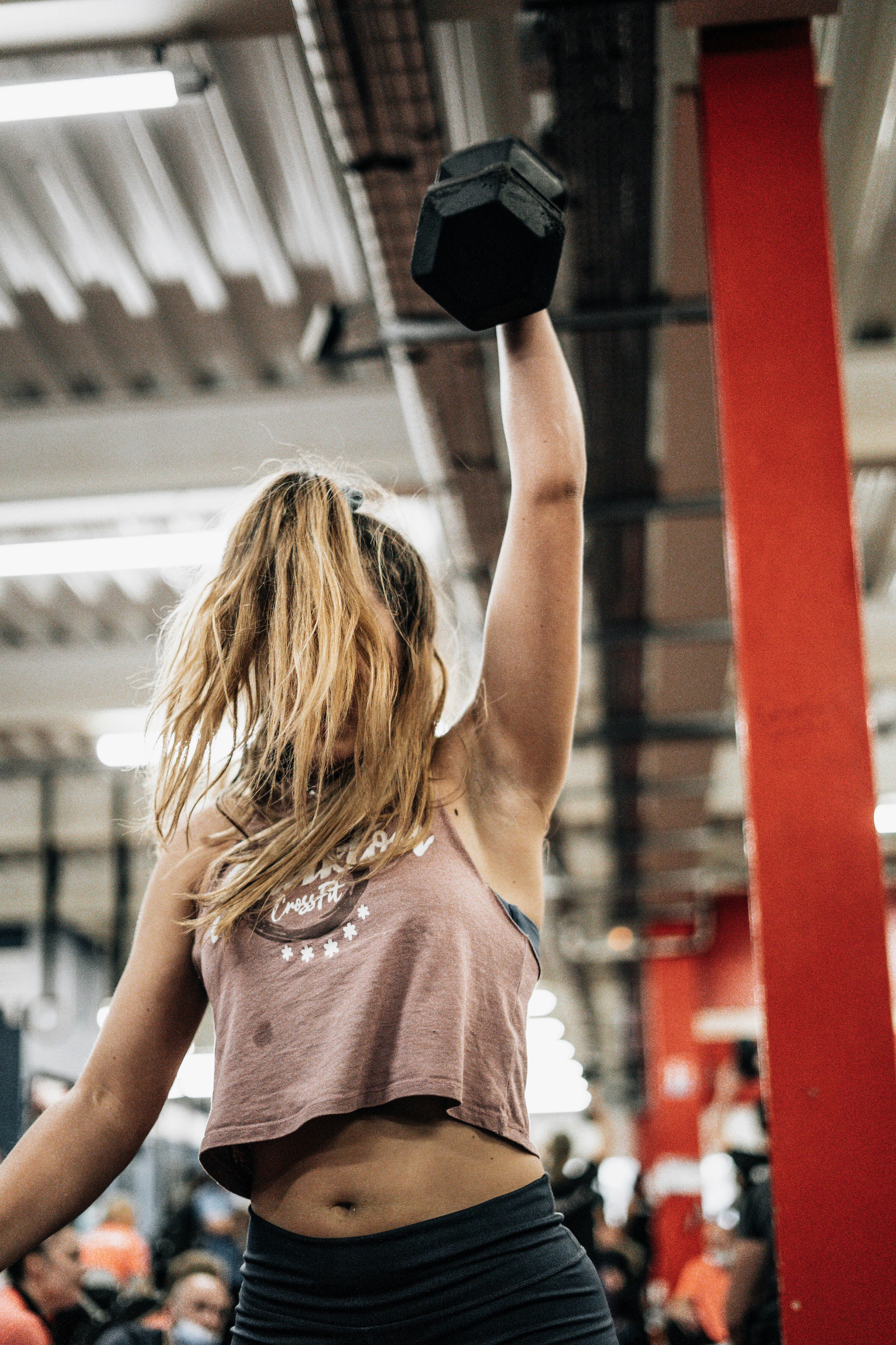 How to Stay Motivated When Working Out Feels Like a Chore – a woman lifting a black dumbbell in a gym