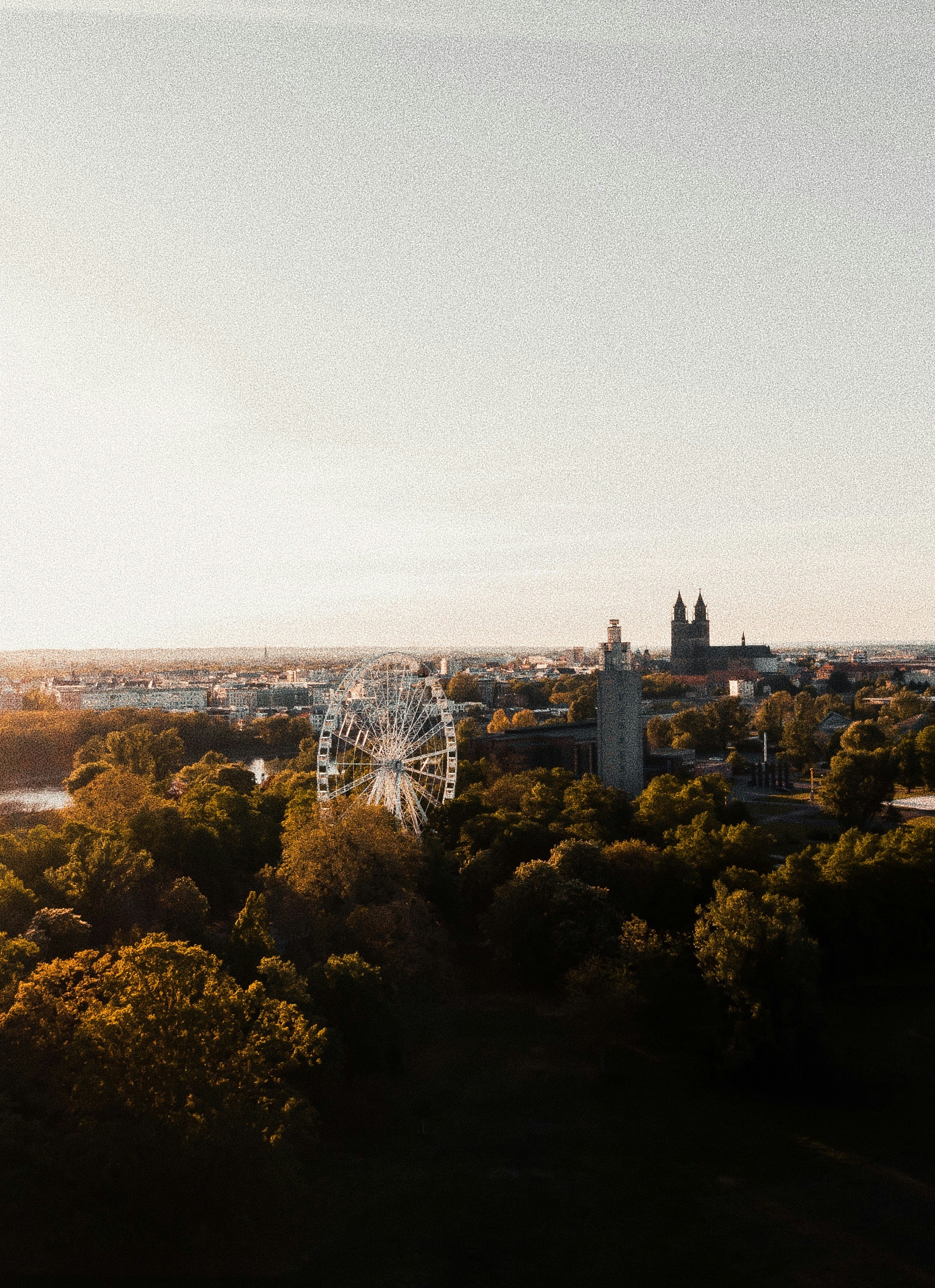 an aerial view of a city with a ferris wheel