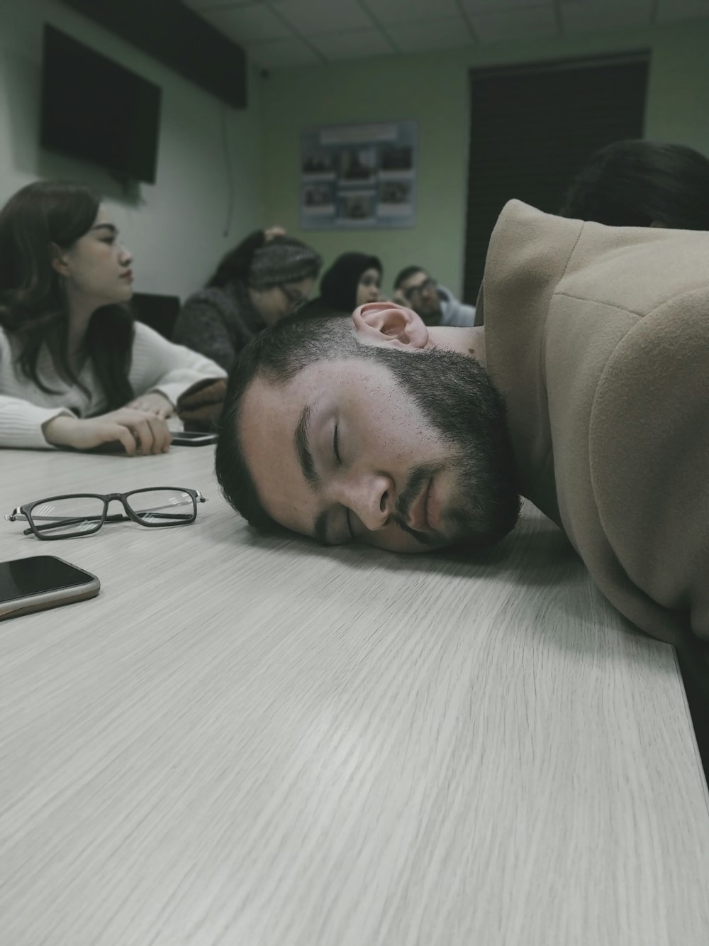 a man laying on a table with his head on the table