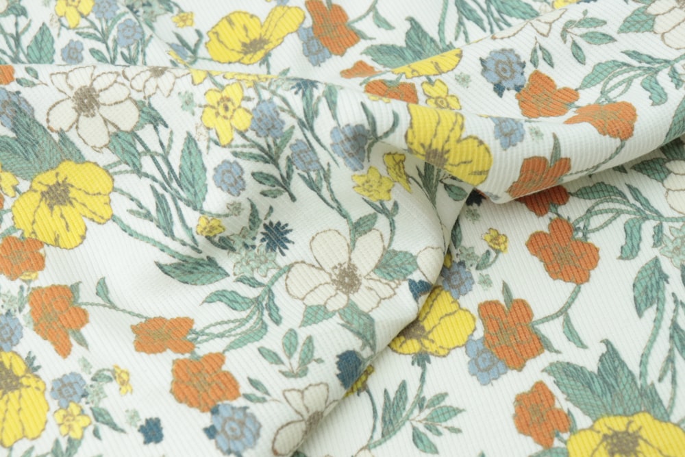 a close up of a flowery fabric with yellow and blue flowers
