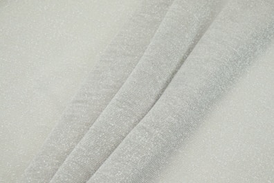 Close-up of luxury collection sheets with subtle sheen and elegant folds in light grey tones.
