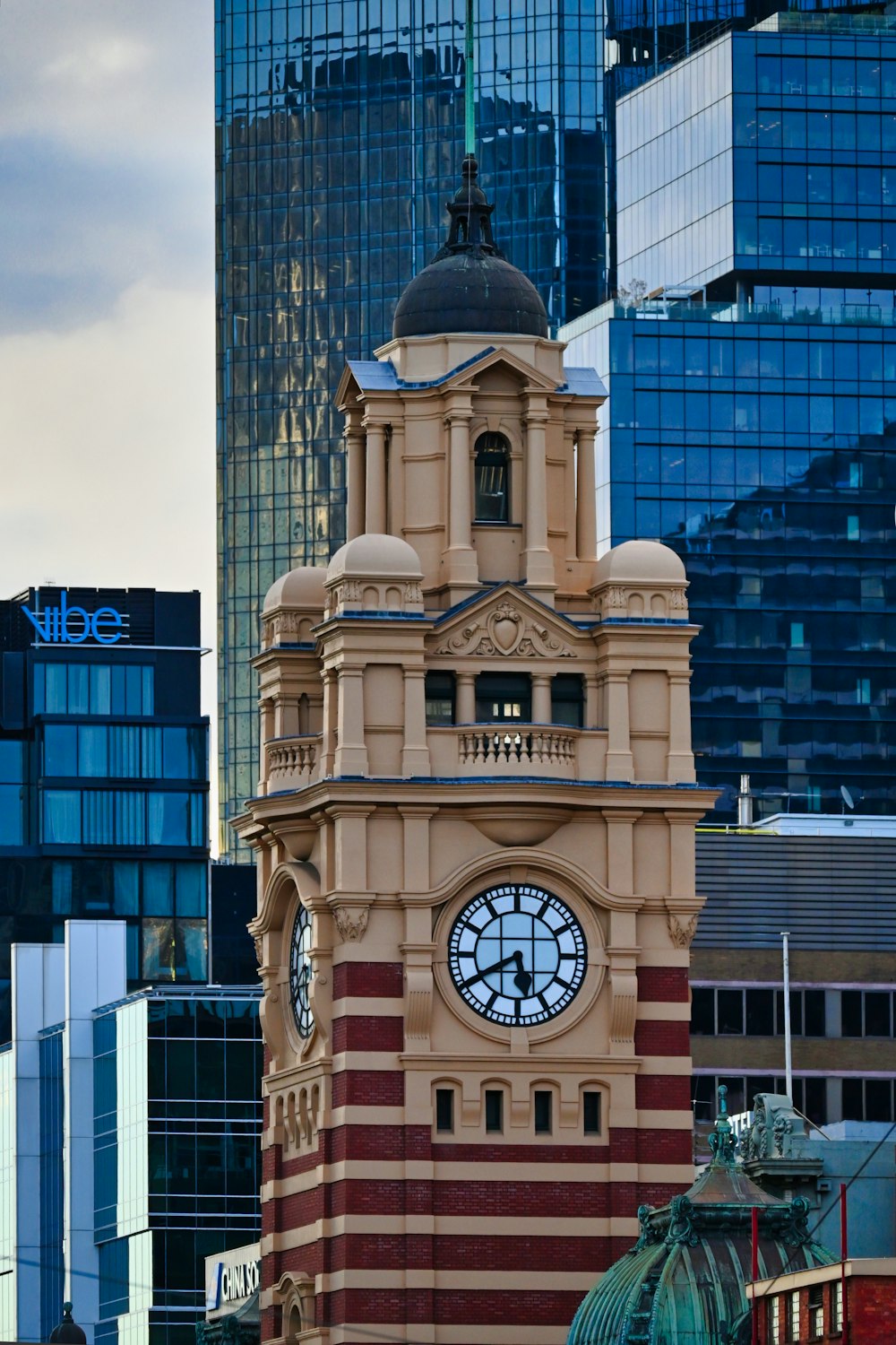 a large clock tower with a sky scraper in the background