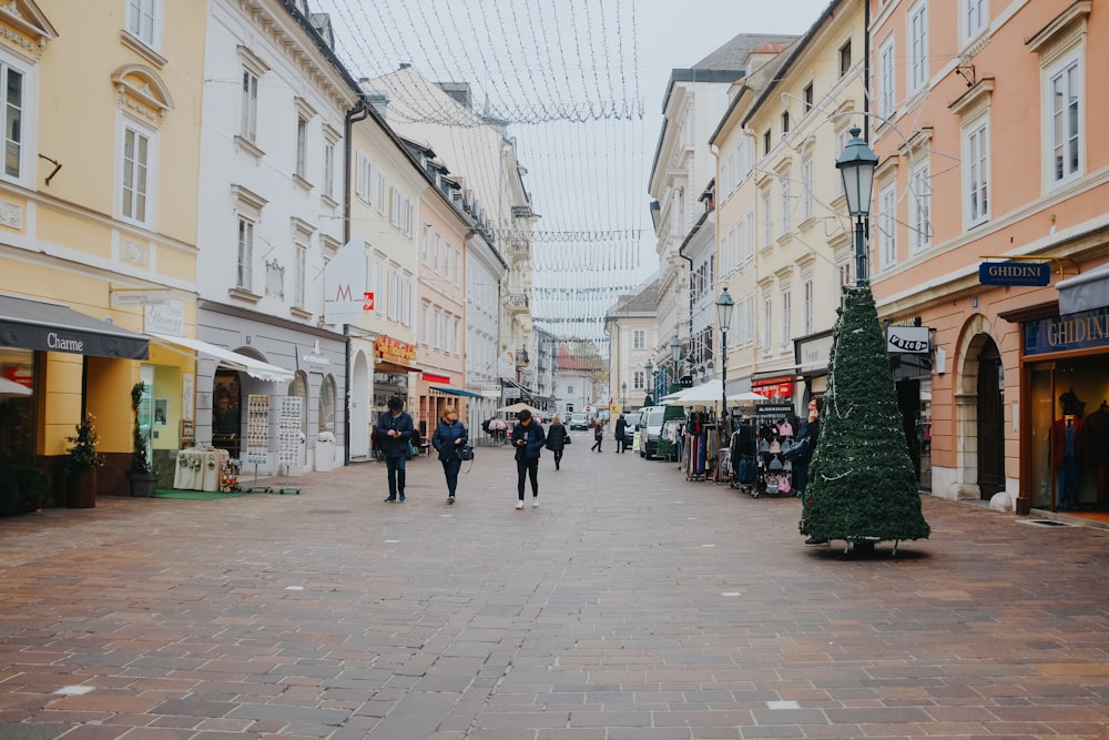 Eine Gruppe von Menschen, die eine Straße neben hohen Gebäuden entlang gehen