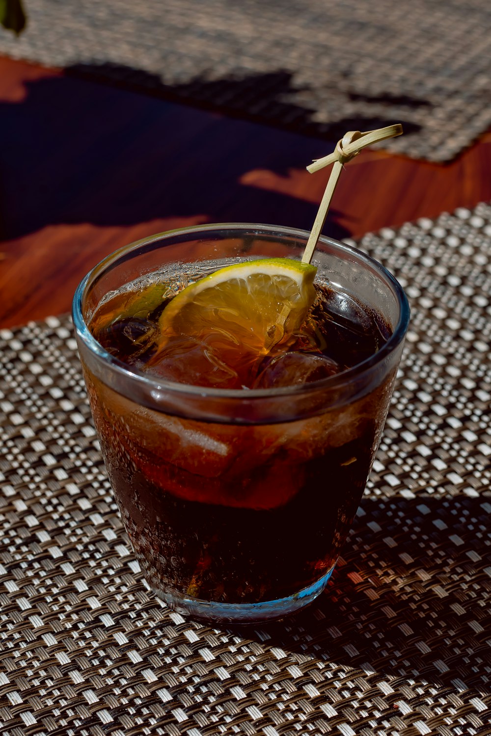 a glass filled with a drink sitting on top of a table