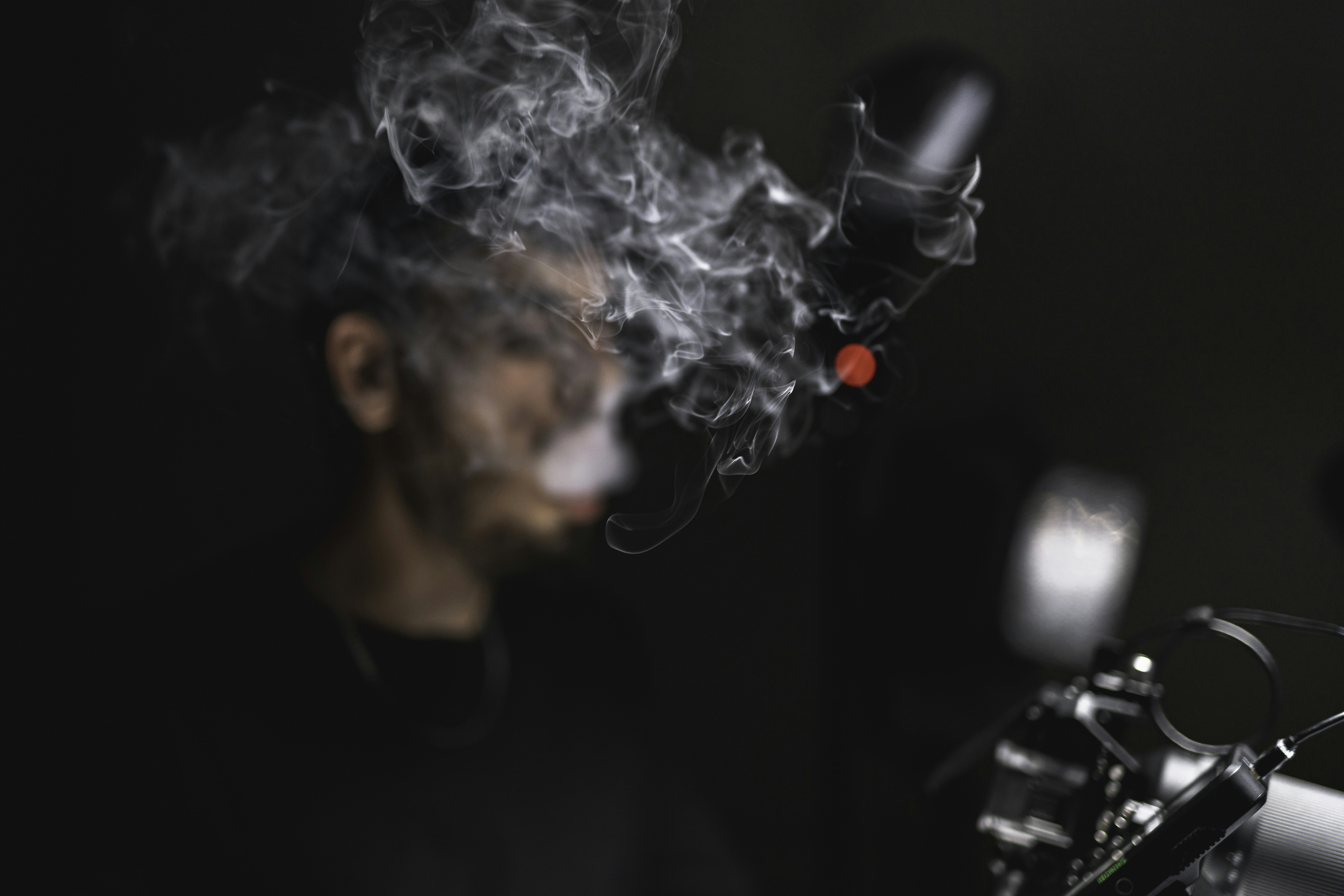 A man smoking a cigarette in a dark room photo – Free Portrait Image on  Unsplash