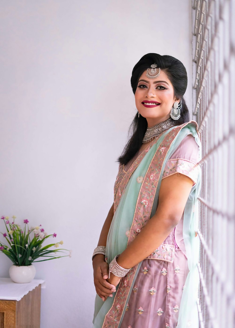 a woman standing next to a wall in a dress