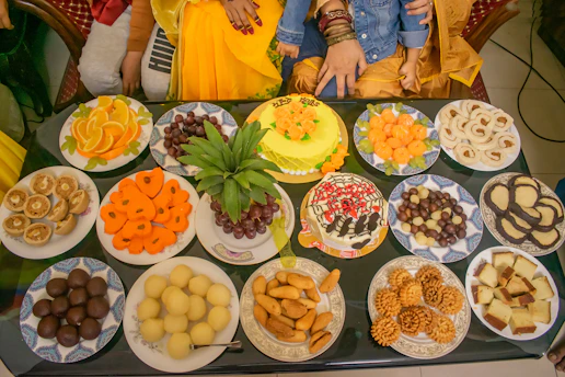 Close-up of colorful tropical bite-size desserts arranged on a rustic wooden table with vibrant natural light.