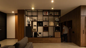 a man standing in a living room next to a couch