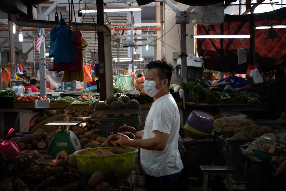 a man wearing a face mask in a market
