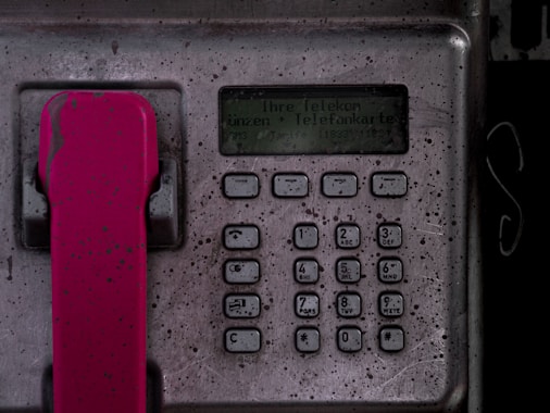 a close up of a phone with a red handle