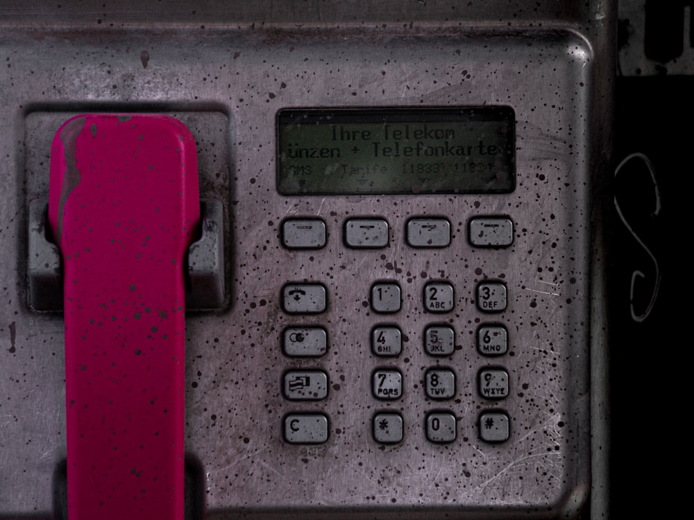 a close up of a phone with a red handle