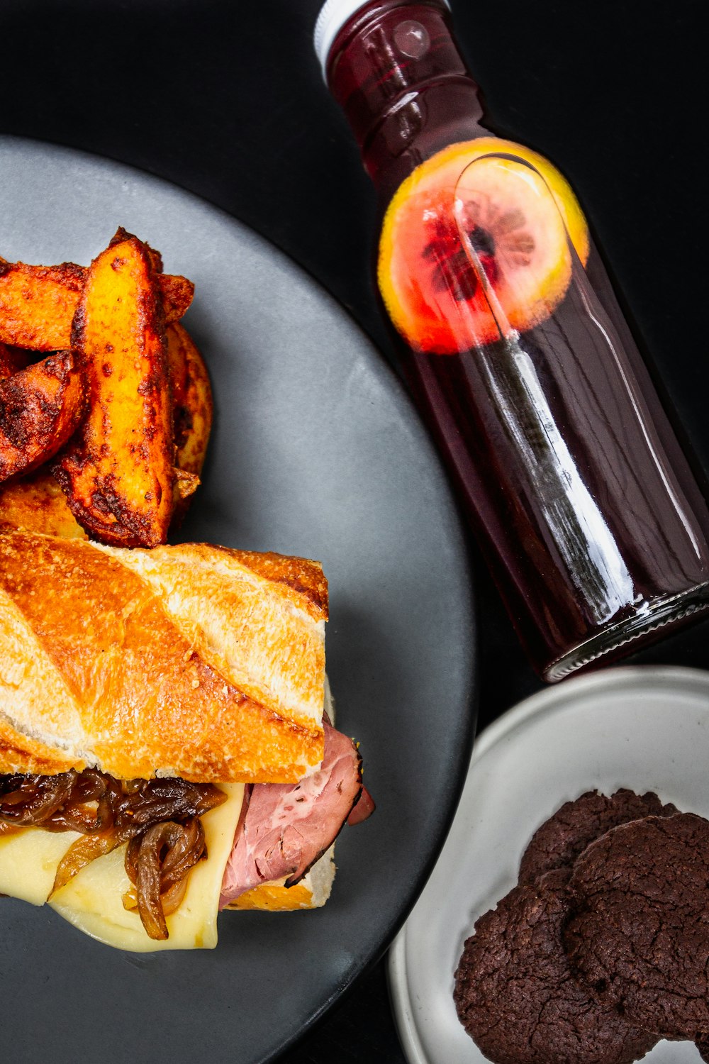 a plate with a sandwich and some chocolate cookies