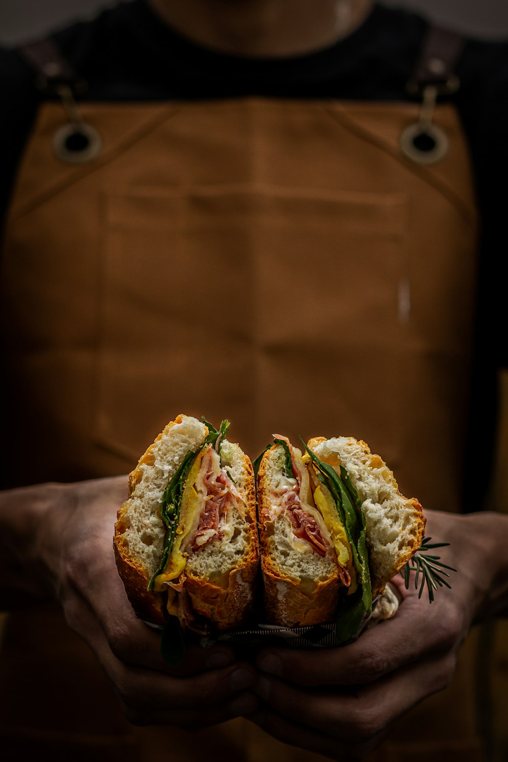 une personne tenant un sandwich dans ses mains