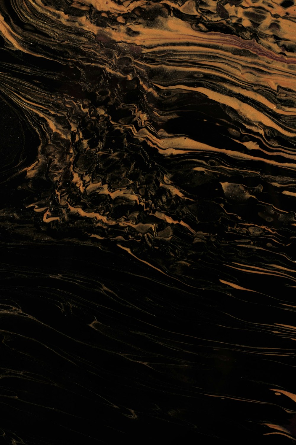 a close up of a black and gold marbled surface