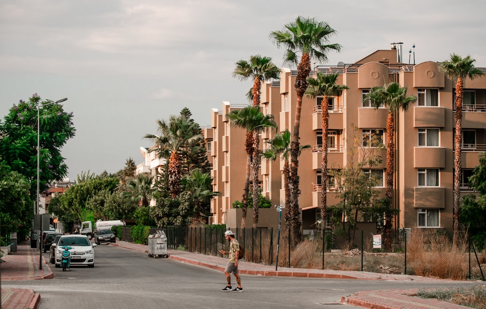 Ein Mann fährt mit einem Skateboard eine Straße neben hohen Gebäuden entlang