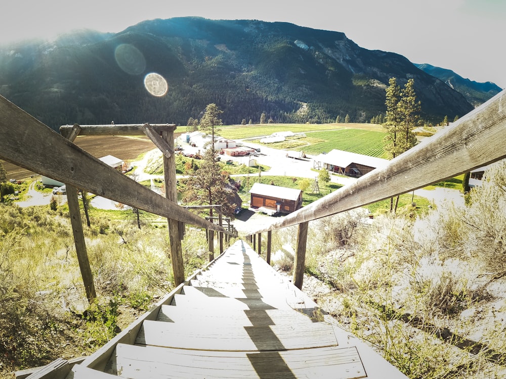 a wooden walkway leading to a small village