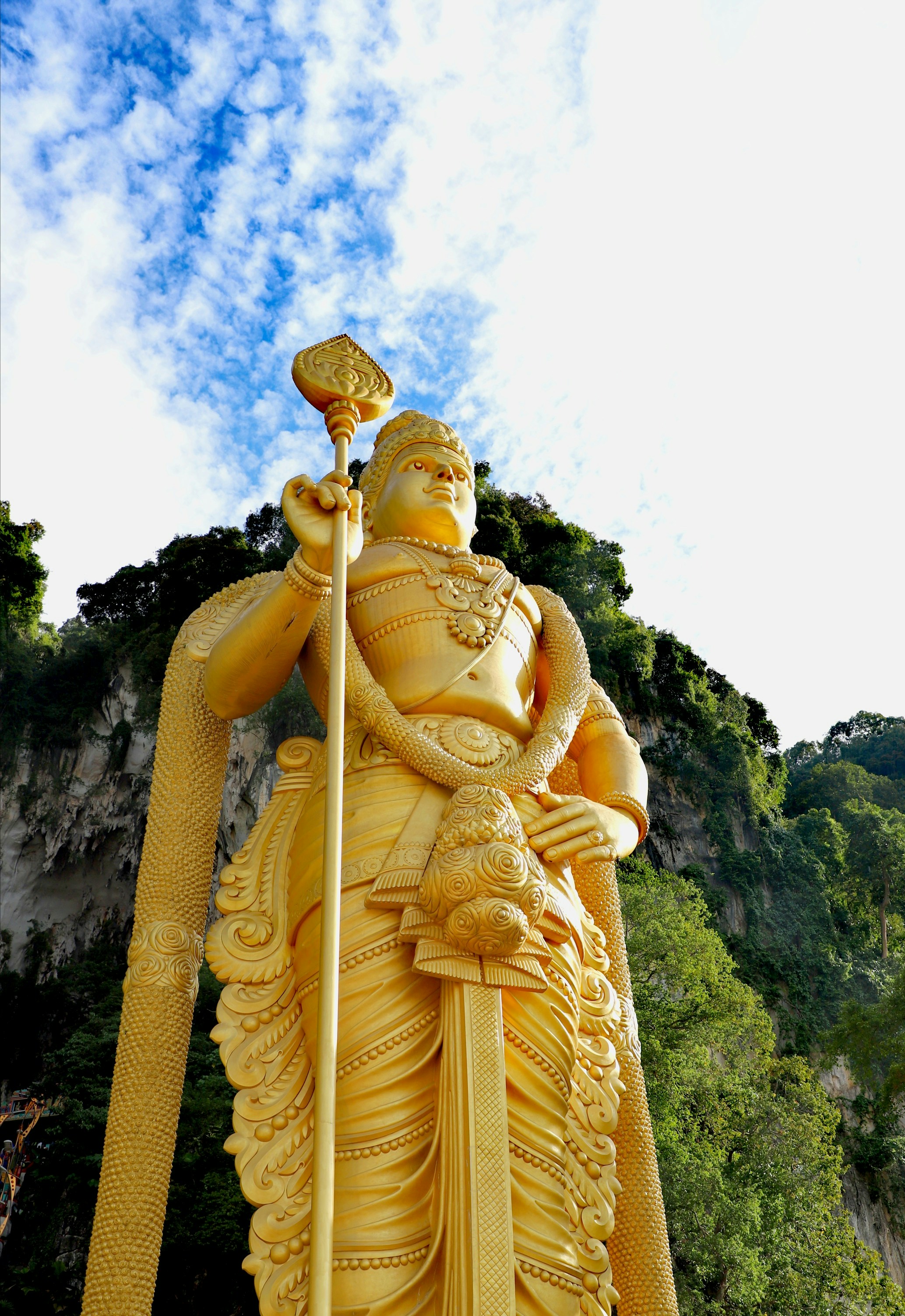 A statue of a god holding a staff in front of a mountain photo ...