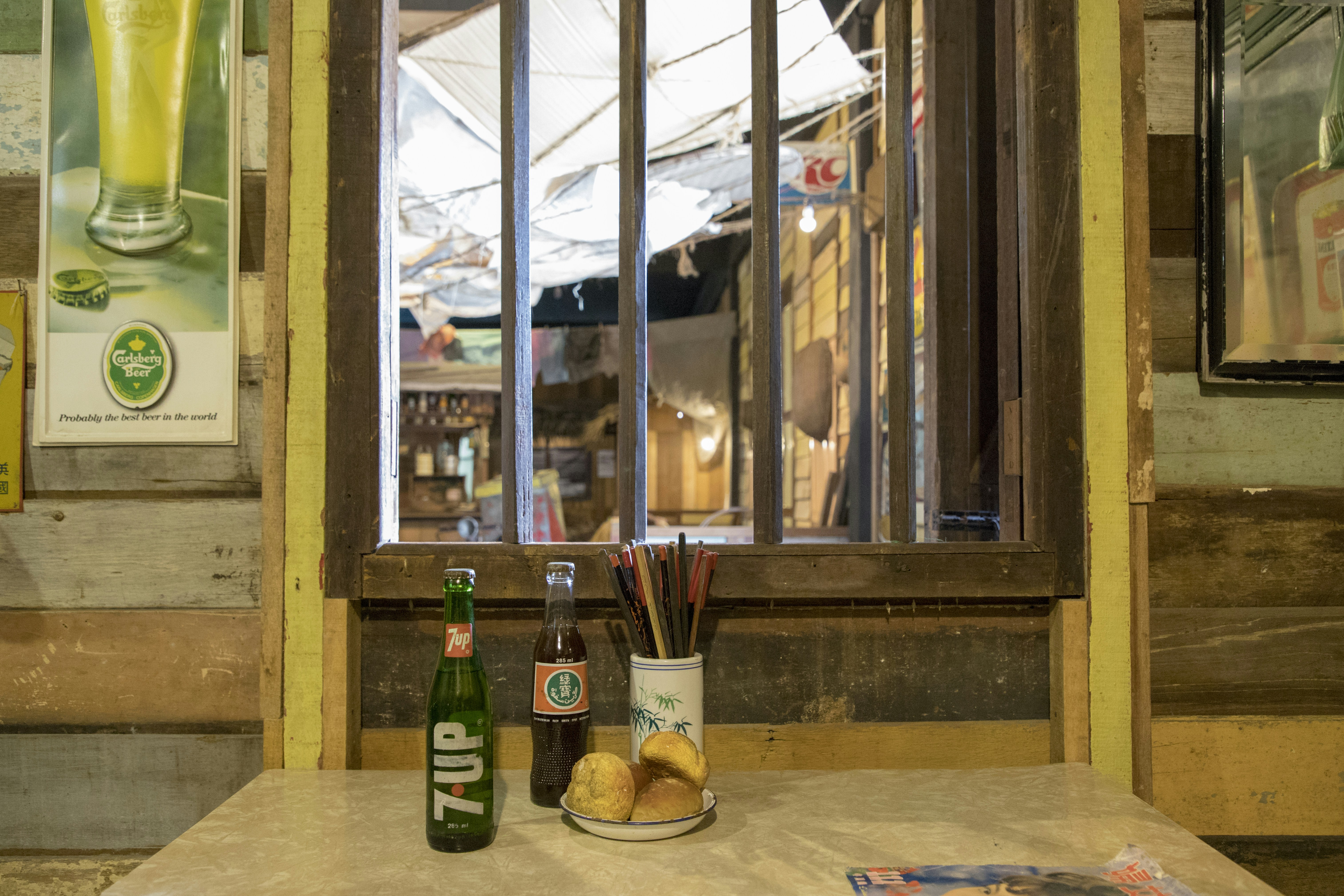 a table topped with bottles of beer next to a window