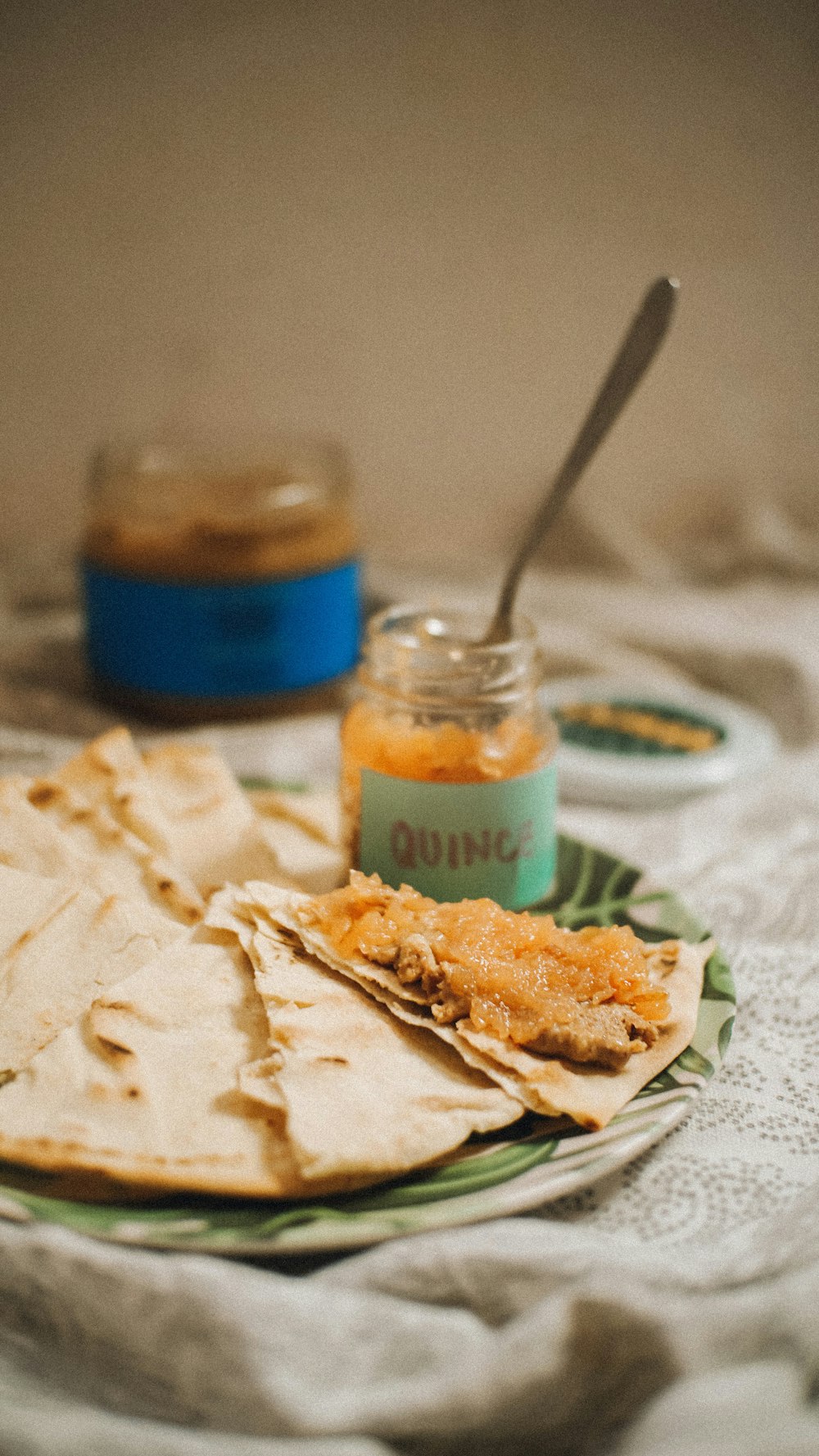 a plate topped with tortillas next to a jar of peanut butter