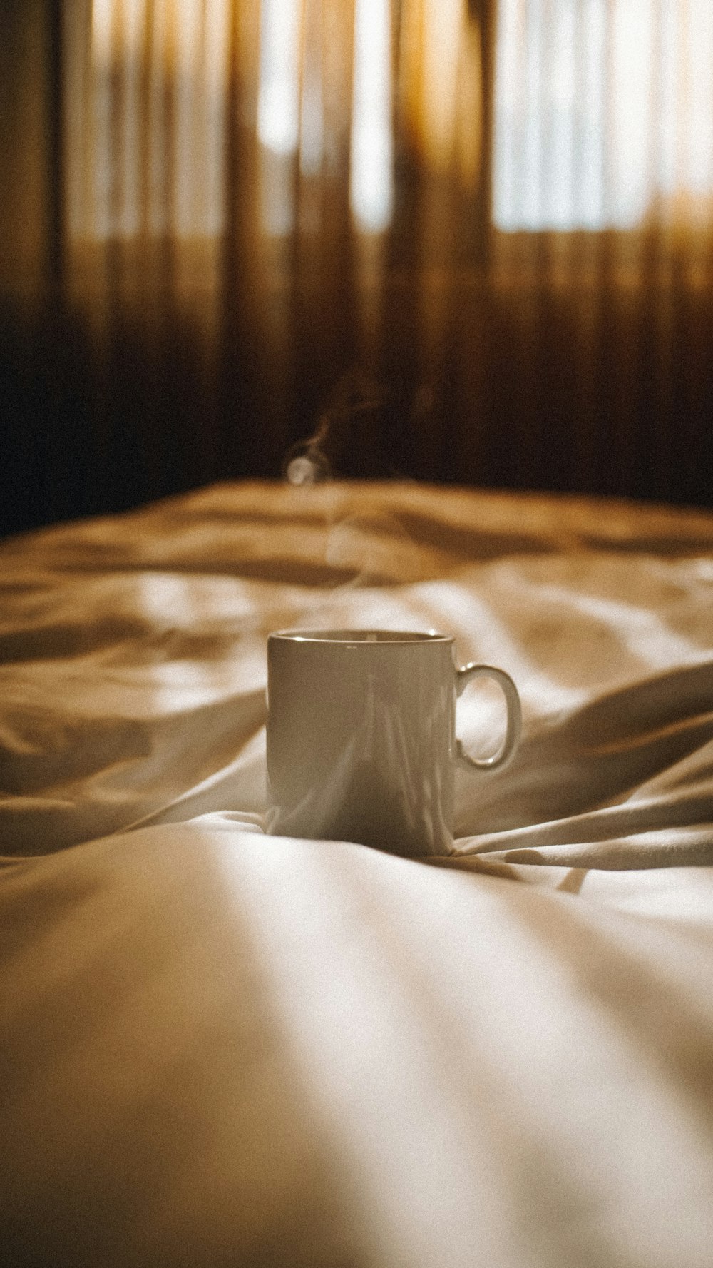a coffee cup sitting on top of a bed