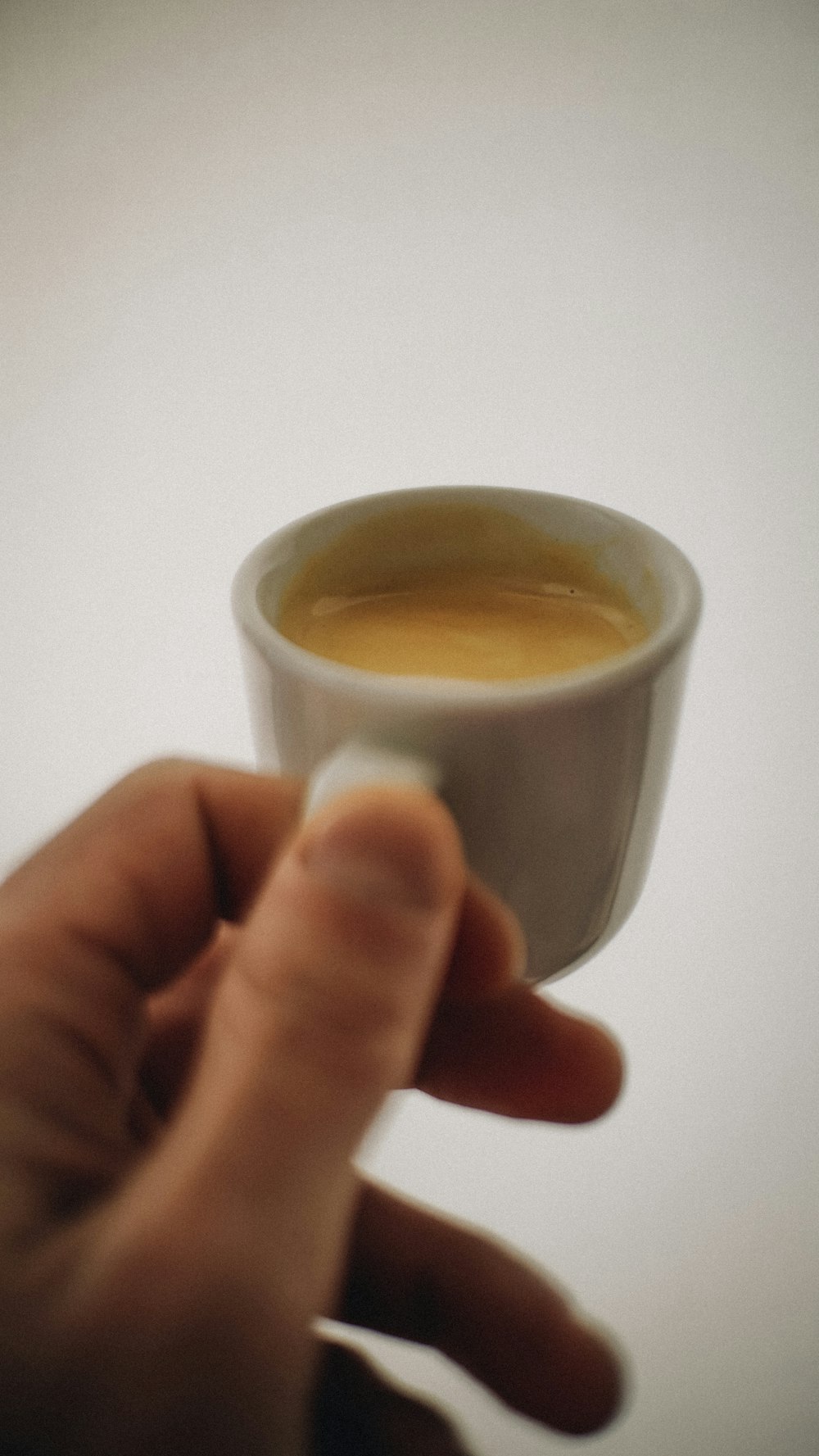 a person holding a cup of coffee in their hand