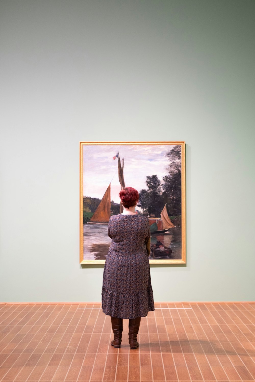 a woman is looking at a painting in a museum
