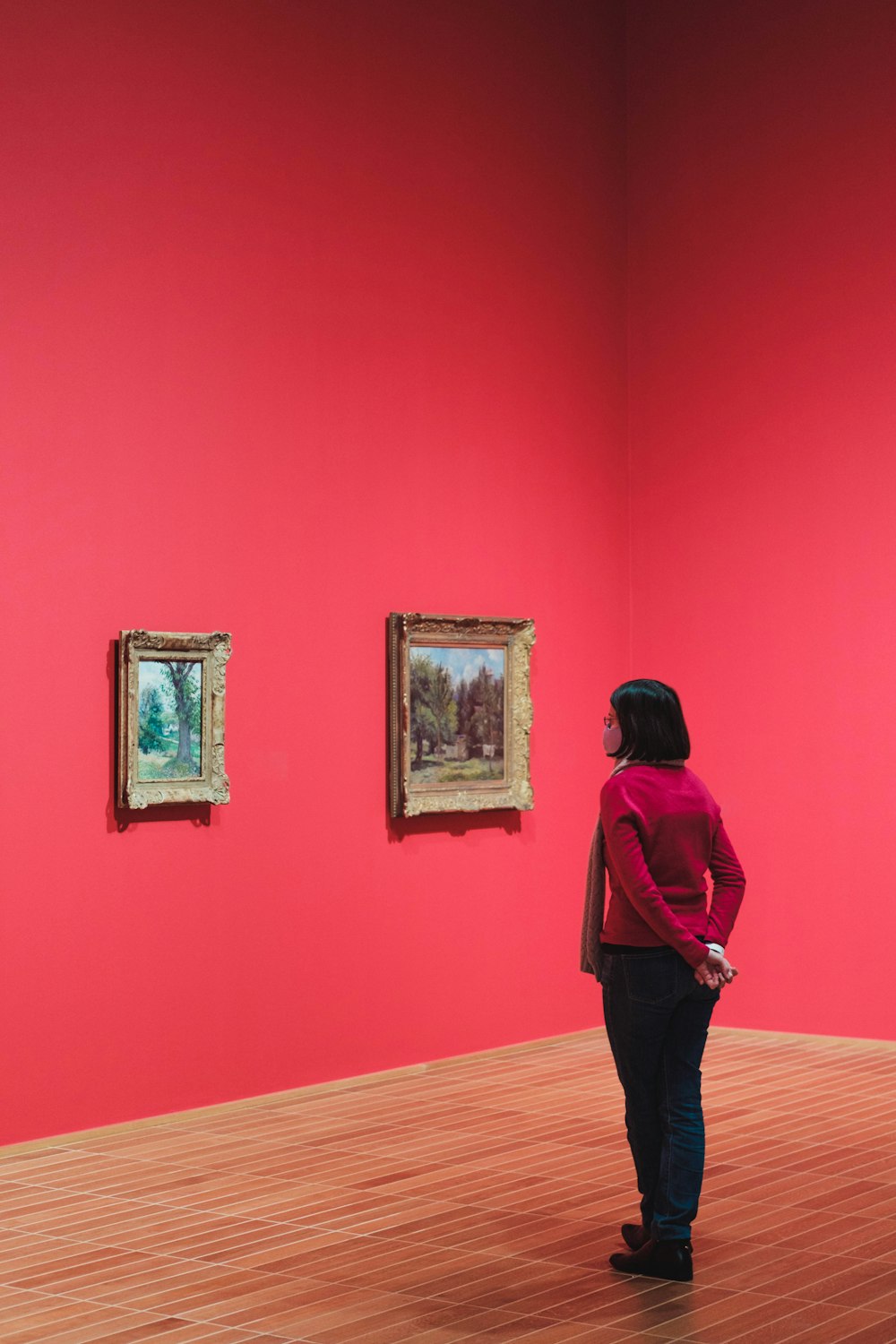 a woman standing in front of paintings in a museum