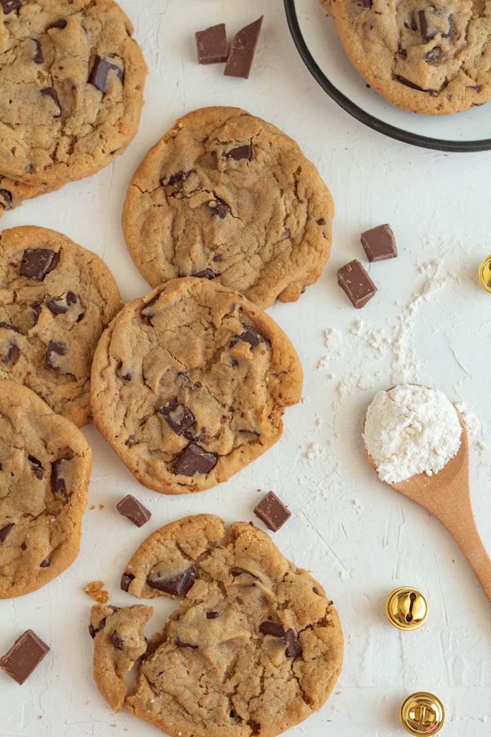 a table topped with chocolate chip cookies and a wooden spoon