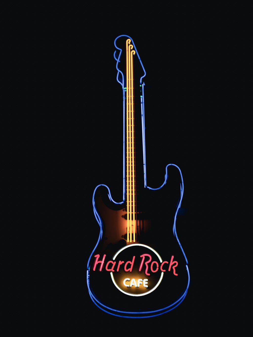 a neon sign for a cafe with a guitar